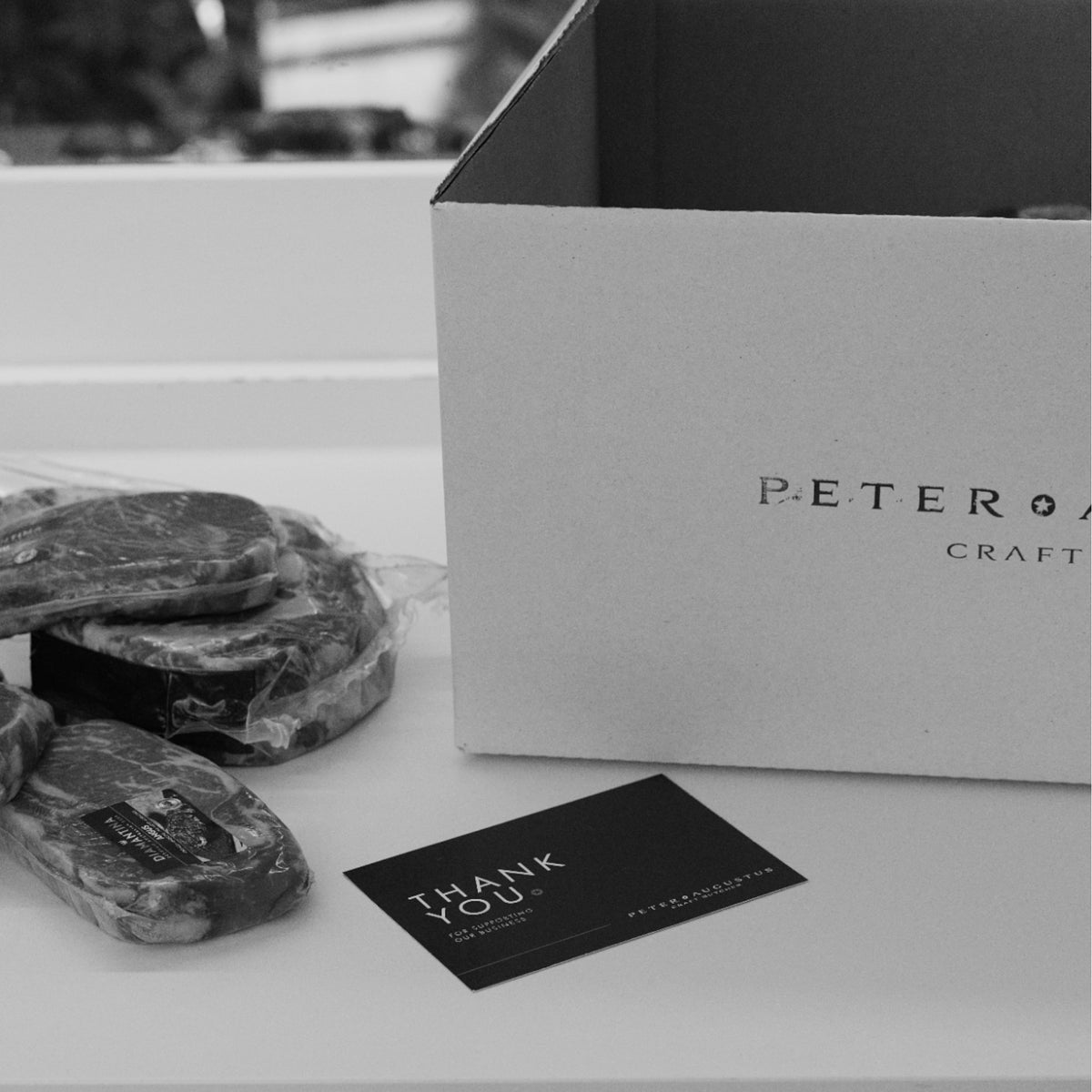 Peter Augustus Craft Butcher box beside vacuum-sealed premium beef steaks and thank you card