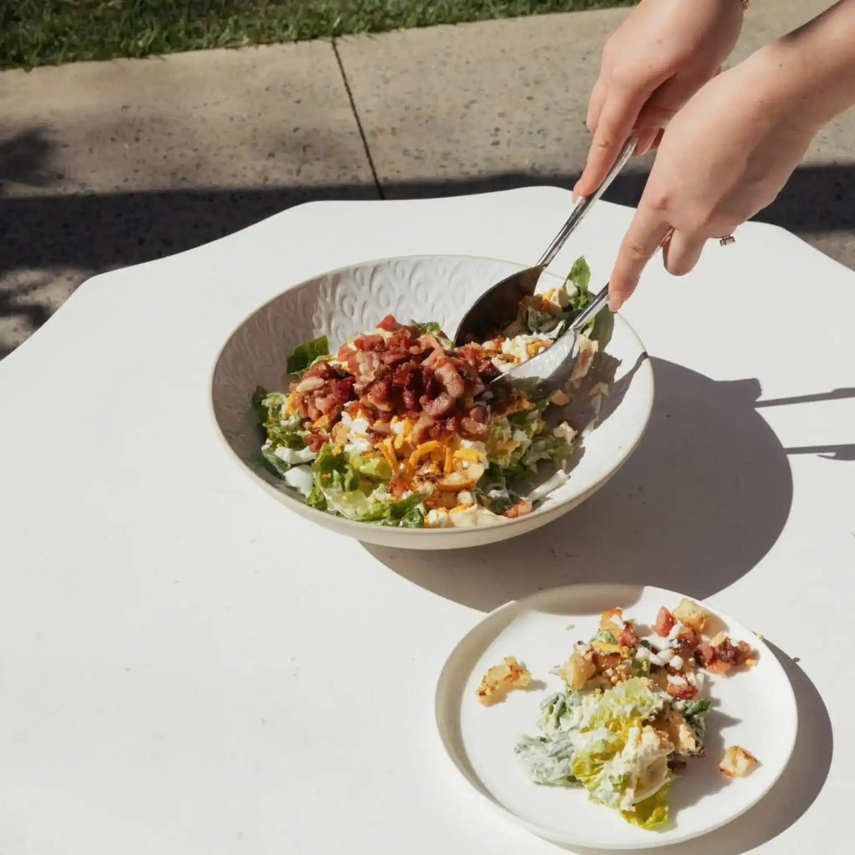 Fresh garden salad with crispy bacon, cheese, and creamy dressing served outdoors
