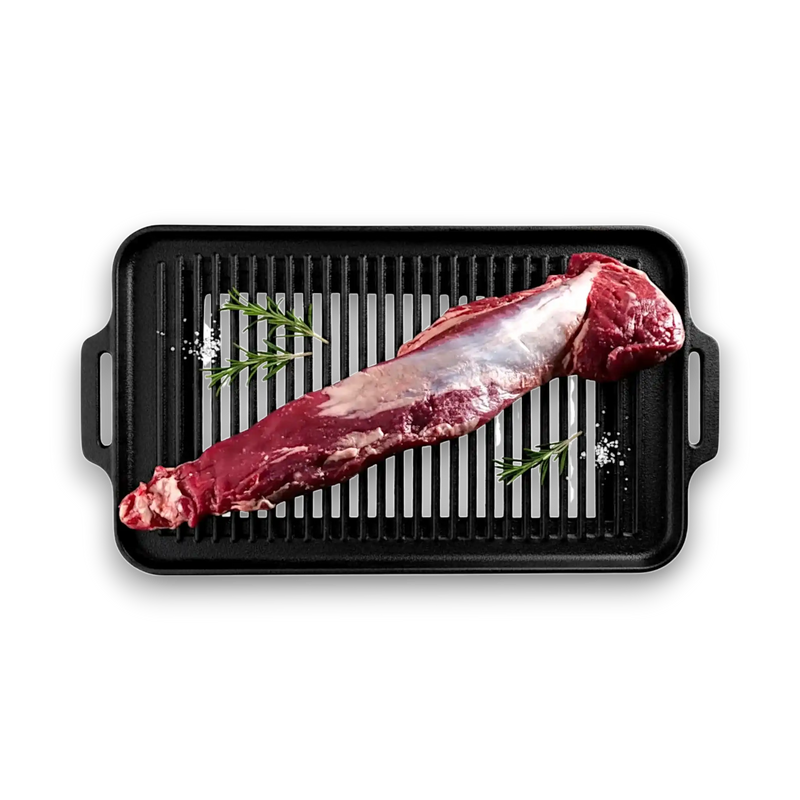 Fresh grass-fed beef tenderloin on black grill pan with rosemary and salt, ready for cooking