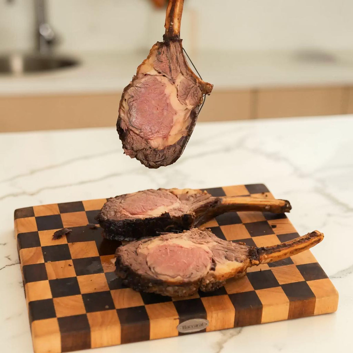 Juicy Wagyu tomahawk steak sliced on checkered board, showcasing marbled beef and bone-in cut