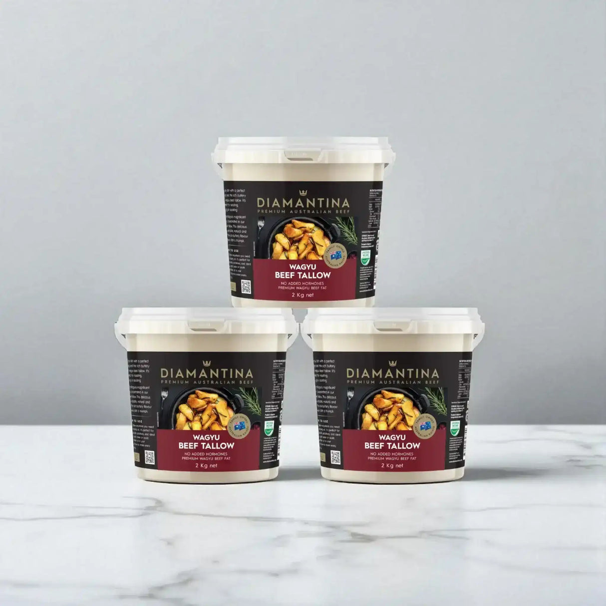 Three 2kg tubs of Diamantina Wagyu beef tallow stacked on a marble surface