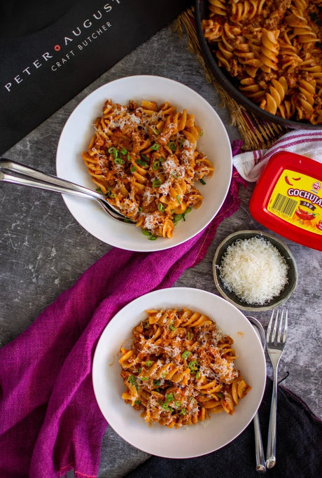 Peter Augustus gourmet beef pasta with cheese and gochujang, served in white bowls