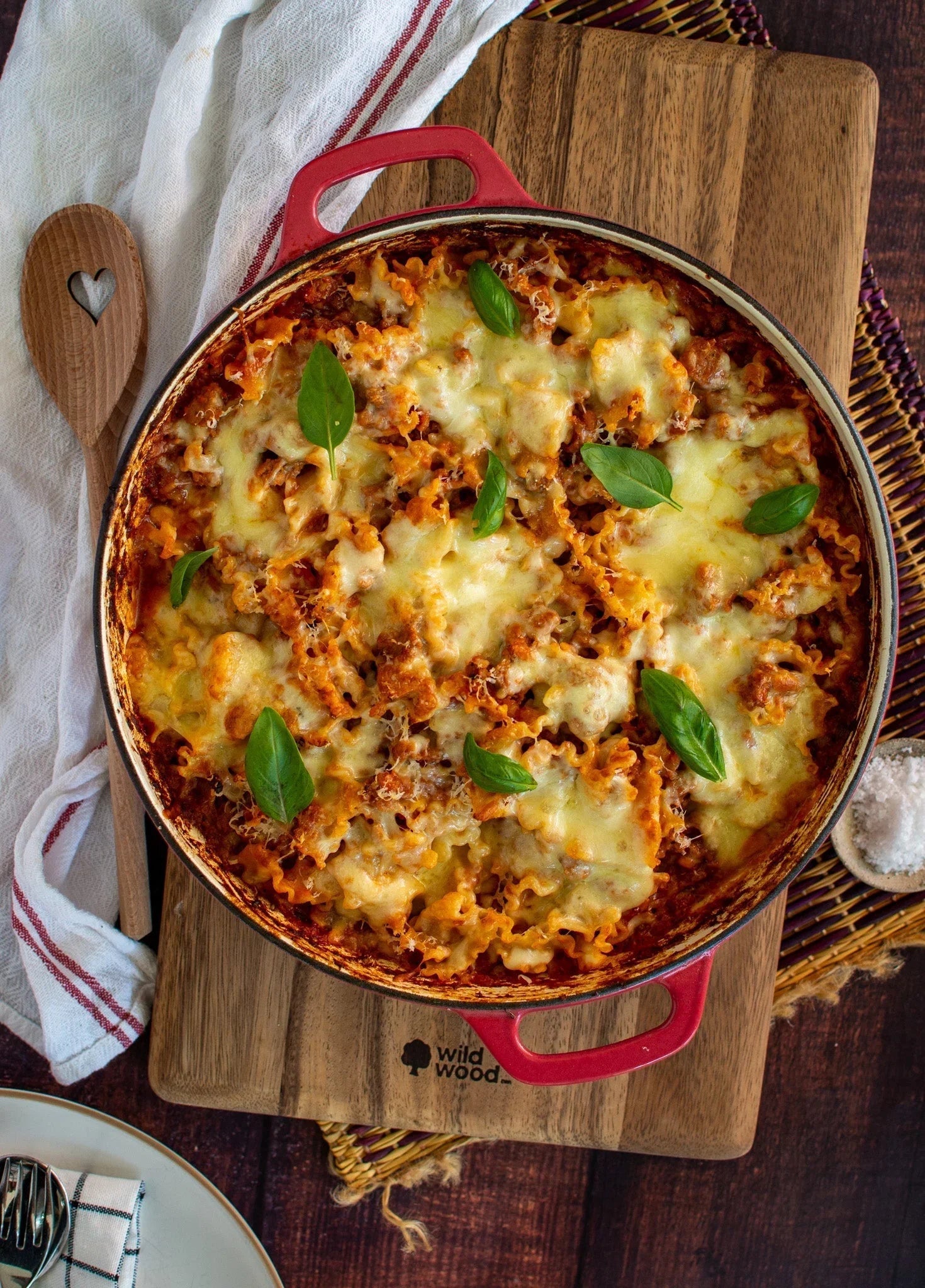Baked beef lasagna with melted cheese and basil in red dish, showcasing premium Australian beef
