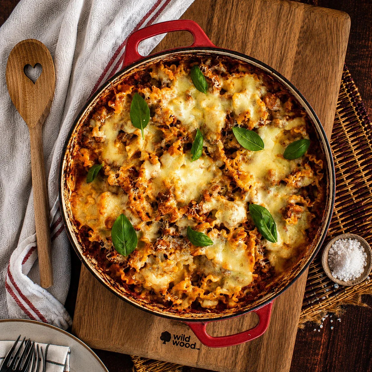 Baked beef lasagna with melted cheese and basil in red dish, showcasing premium Australian beef