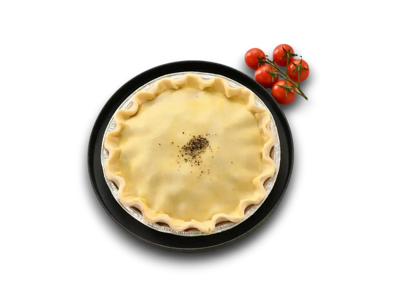 Unbaked chunky beef pie with golden crust and pepper, side of vine tomatoes on white marble