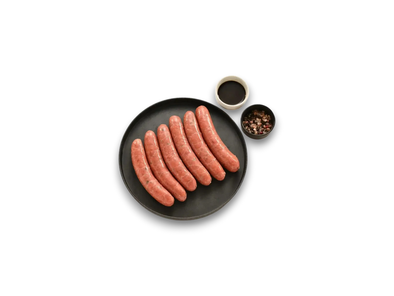 Peter Augustus Wagyu Worcestershire sausages on black plate with sauce and peppercorns