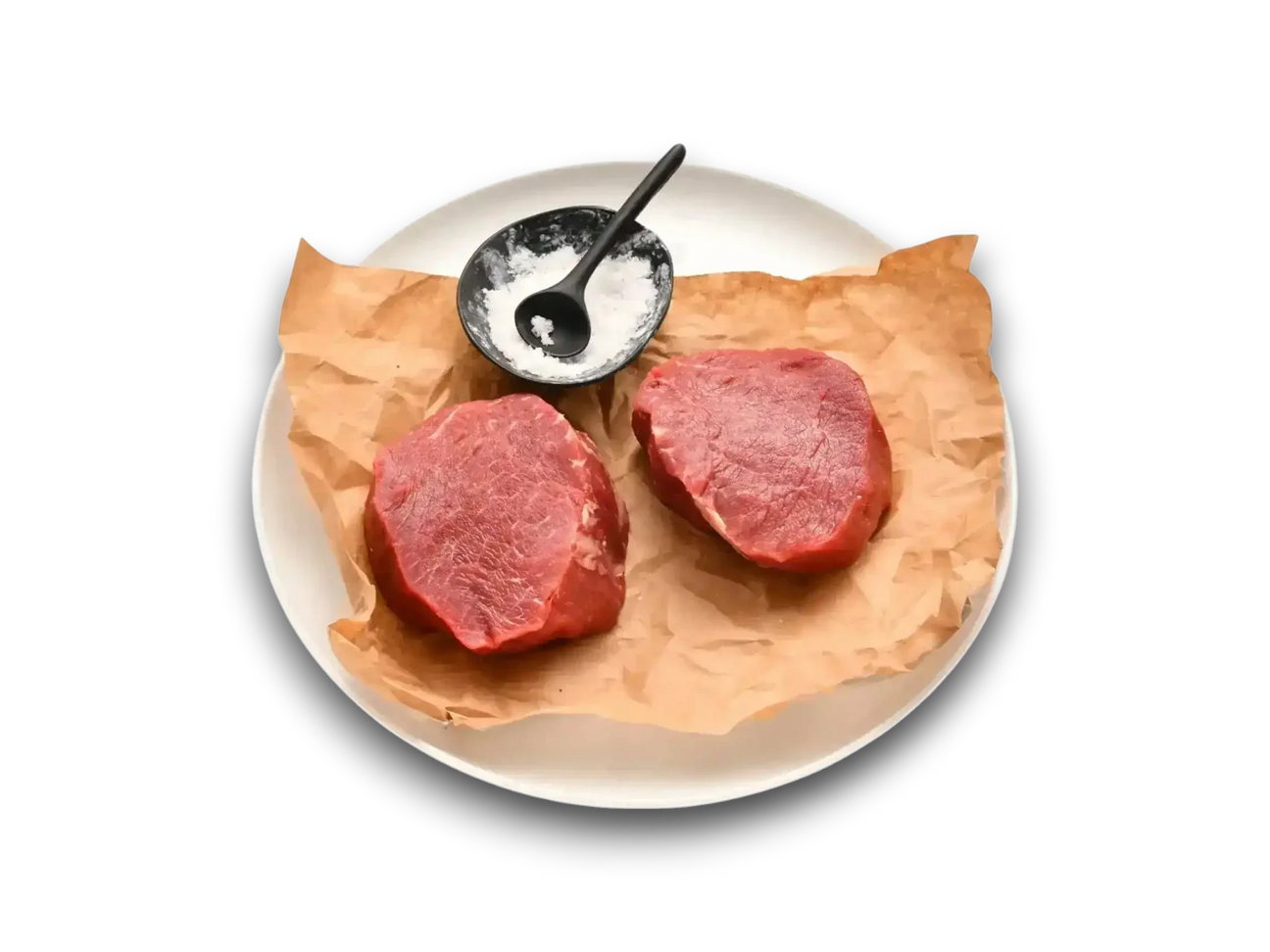 Two raw Diamantina grain-fed eye fillet steaks on parchment with a bowl of salt