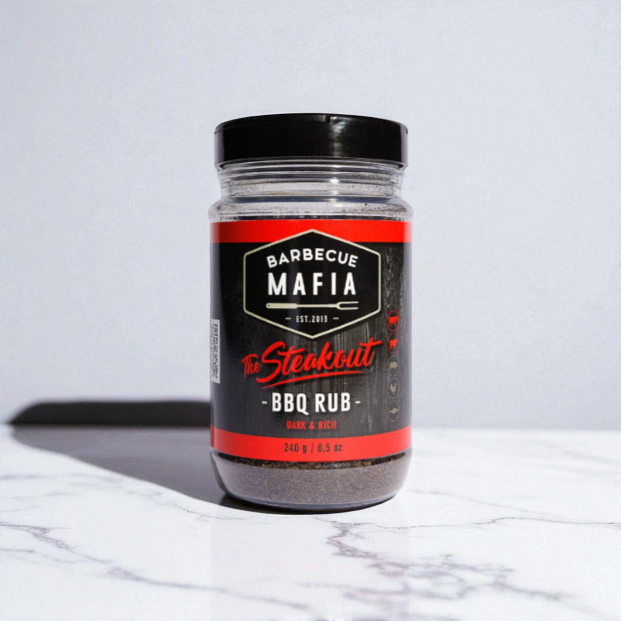 Selection of BBQ sauces, dry rubs, and gourmet condiments displayed with premium meat cuts