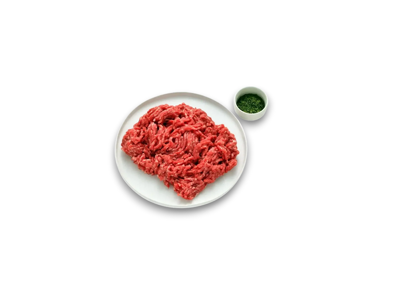 Fresh grass-fed beef mince on a white plate, with chopped herbs in a small bowl, on marble surface.
