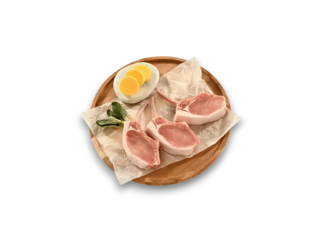 Three raw free-range pork cutlets with fresh herbs and yellow squash slices on a wooden board
