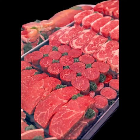 Display case of fresh Australian beef steaks and gourmet cuts on parsley garnish