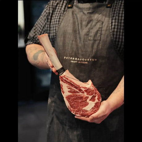 Butcher holding marbled Australian tomahawk steak at Peter Augustus Craft Butcher