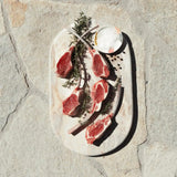 Australian lamb chops on marble board with rosemary and salt from Peter Augustus Craft Butcher