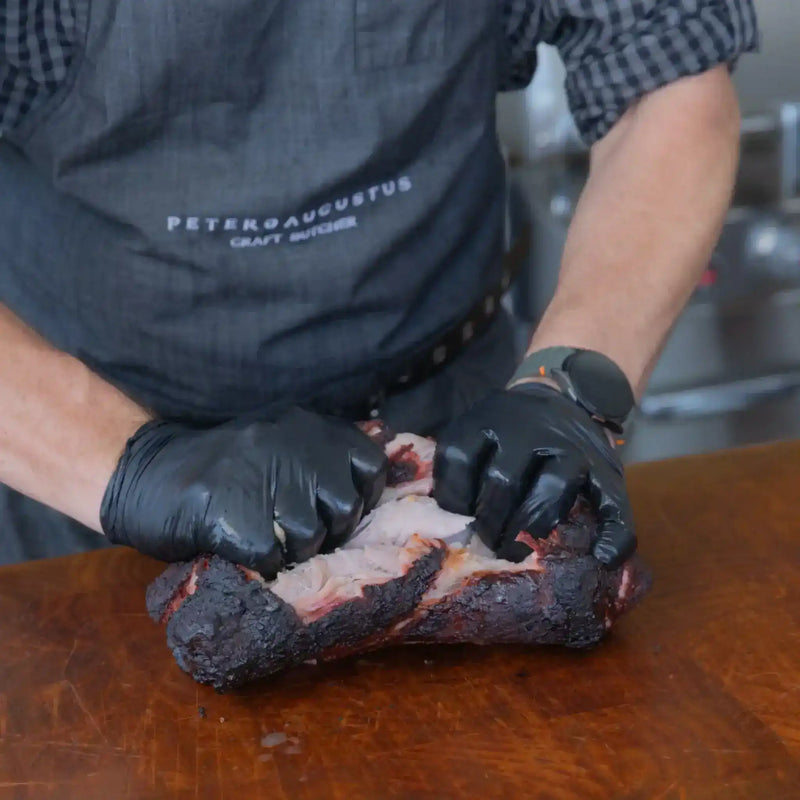 Peter Augustus butcher shredding smoked Australian beef brisket with gloves