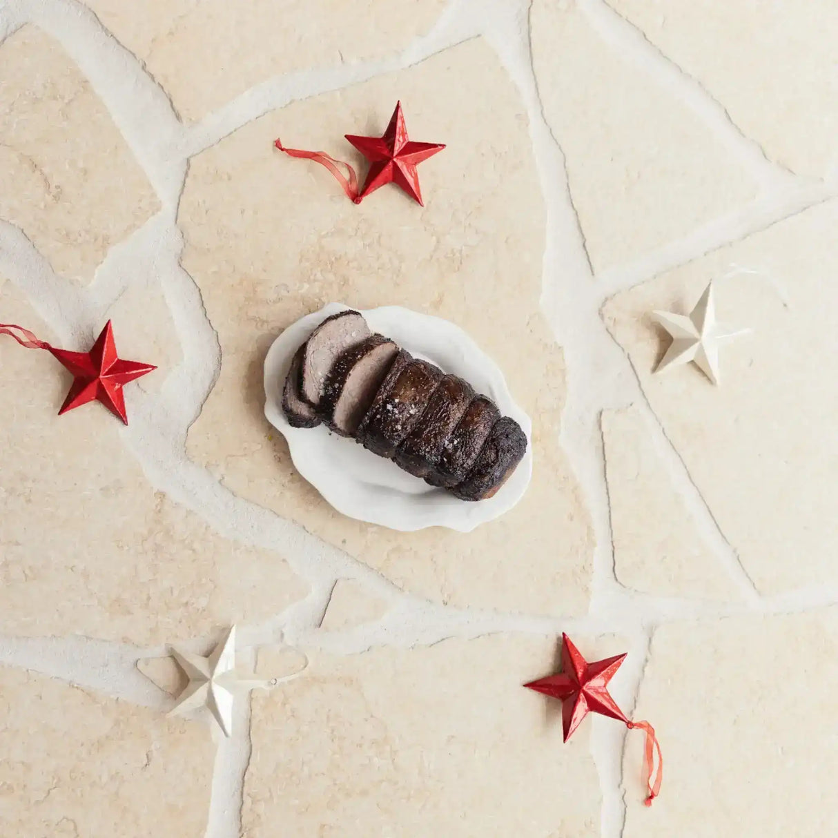 Sliced Australian beef roast on a white plate with red and white star decorations, Peter Augustus
