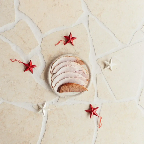 Sliced roast pork on a plate with red and white star decorations, Peter Augustus butcher