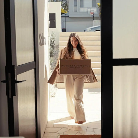 Woman smiling while delivering a Peter Augustus Craft Butcher box to a doorstep