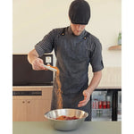 Butcher in apron seasoning premium Australian beef in a mixing bowl at Peter Augustus Craft Butcher