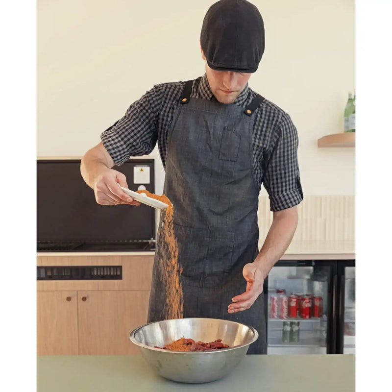 Butcher in apron seasoning premium Australian beef in a mixing bowl at Peter Augustus Craft Butcher