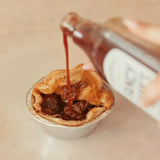 Rich brown gravy poured over chunky beef meat pie in a golden flaky crust