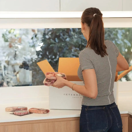 Woman unpacking premium Australian beef from Peter Augustus Craft Butcher delivery box