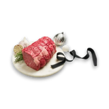 Premium marbled beef roast with rosemary, garlic, and festive ornaments on marble platter