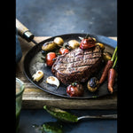 Grilled Australian beef steak with roasted tomatoes, potatoes, garlic and carrots on plate