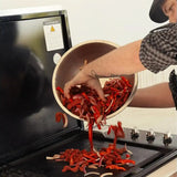 Person grilling premium Australian beef strips with red peppers and onions on a barbecue