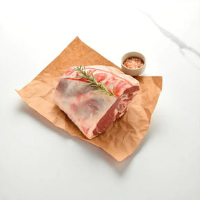 Fresh bone-in lamb leg with rosemary on butcher paper, premium meat from Peter Augustus