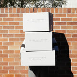 Three Peter Augustus Craft Butcher delivery boxes stacked outdoors against a brick wall