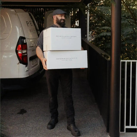 Peter Augustus Craft Butcher delivery driver holding premium meat boxes beside branded van