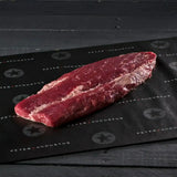 Whole raw Angus eye fillet on black butcher paper, Australian beef specialty cut