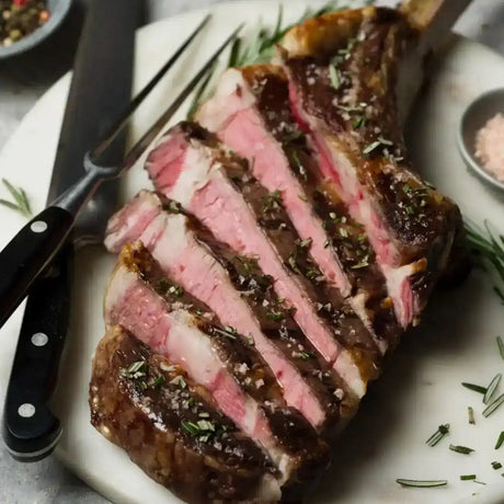Sliced Diamantina Angus tomahawk steak with fresh herbs on a plate, Peter Augustus butcher