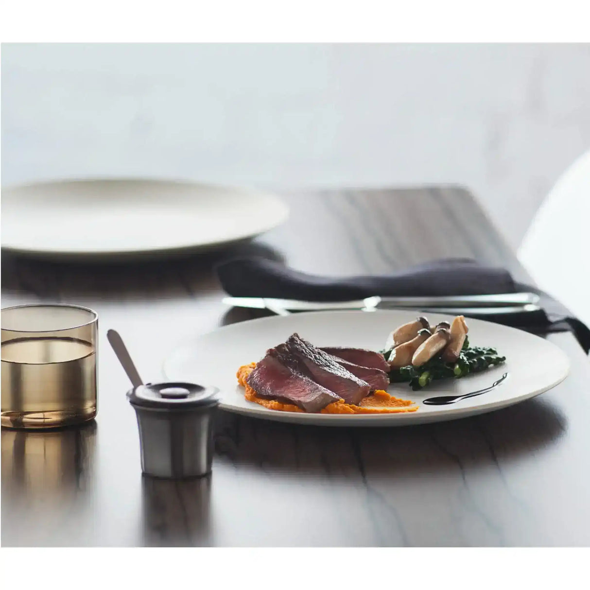 Sliced Diamantina grass-fed eye fillet steak with puree and vegetables on a white plate