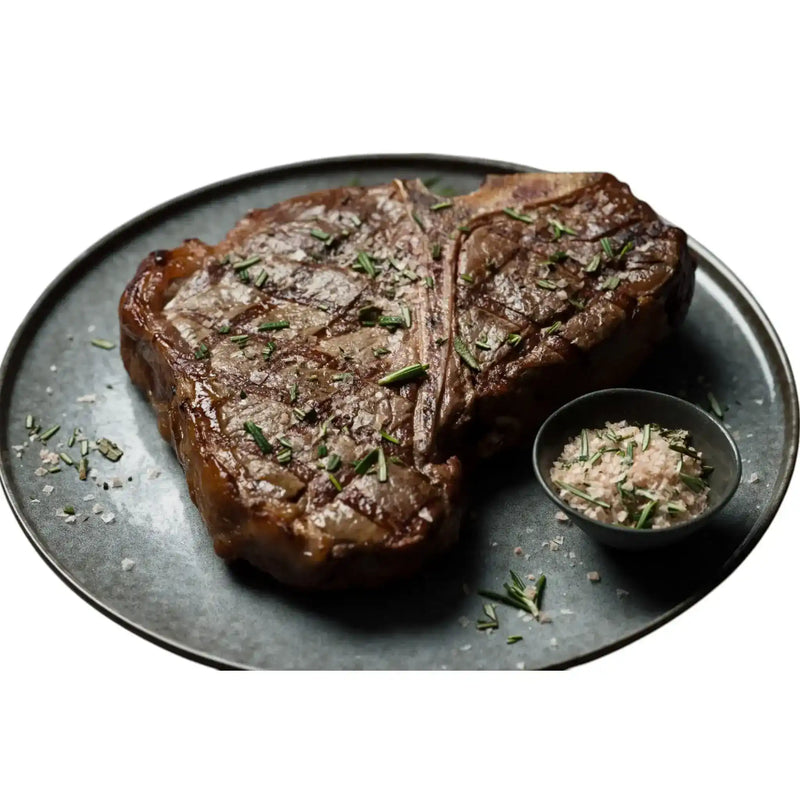 Grilled Diamantina Angus T-bone steak with sea salt and herbs on a plate from Peter Augustus