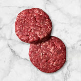 Two raw Diamantina Wagyu beef burger patties on a white marble surface