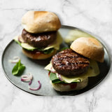 Juicy Diamantina wagyu beef burgers with cheese, greens, and onions on artisan buns