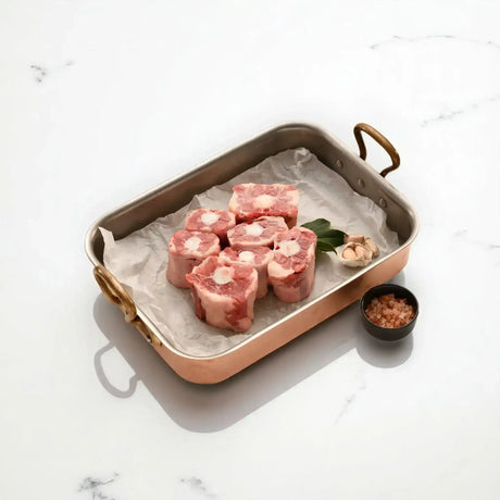 Diamantina Australian oxtail pieces in roasting pan with bay leaf, garlic, and pink salt, Peter Augustus