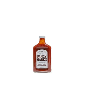 Fancy Hank's tomato sauce in a clear glass bottle with a white label on white background
