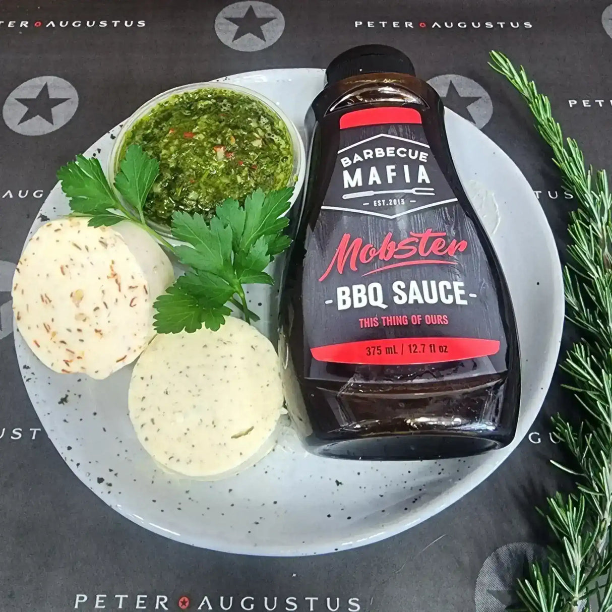 Gourmet condiment pack with BBQ sauce, herb butter, salsa verde, and fresh parsley on a plate