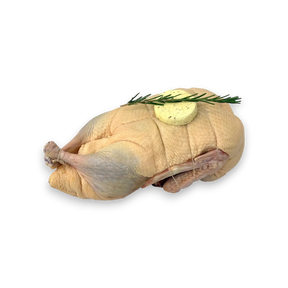 Raw chicken with butter and rosemary on a white background
