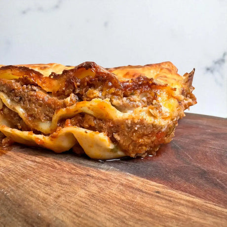 Close-up of gourmet beef lasagna slice with rich meat and cheese layers from Peter Augustus