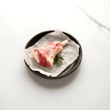 Raw lamb shank with rosemary on parchment in a black dish, Peter Augustus Craft Butcher
