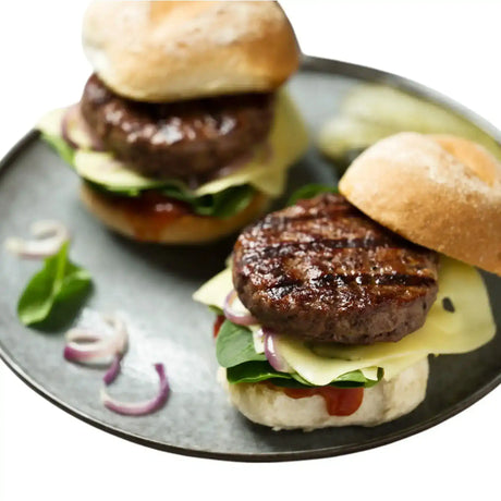 Angus beef burgers with cheese, spinach, and onions on buns, served on a plate