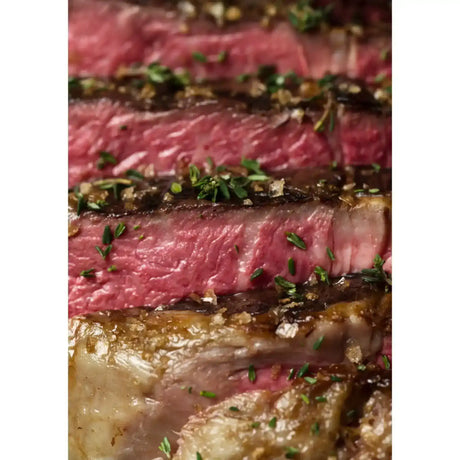 Close-up of sliced cooked Wagyu tomahawk steak with herbs and coarse salt