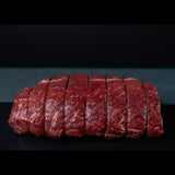 Raw beef roast tied and portioned, premium Australian beef with visible marbling on black background