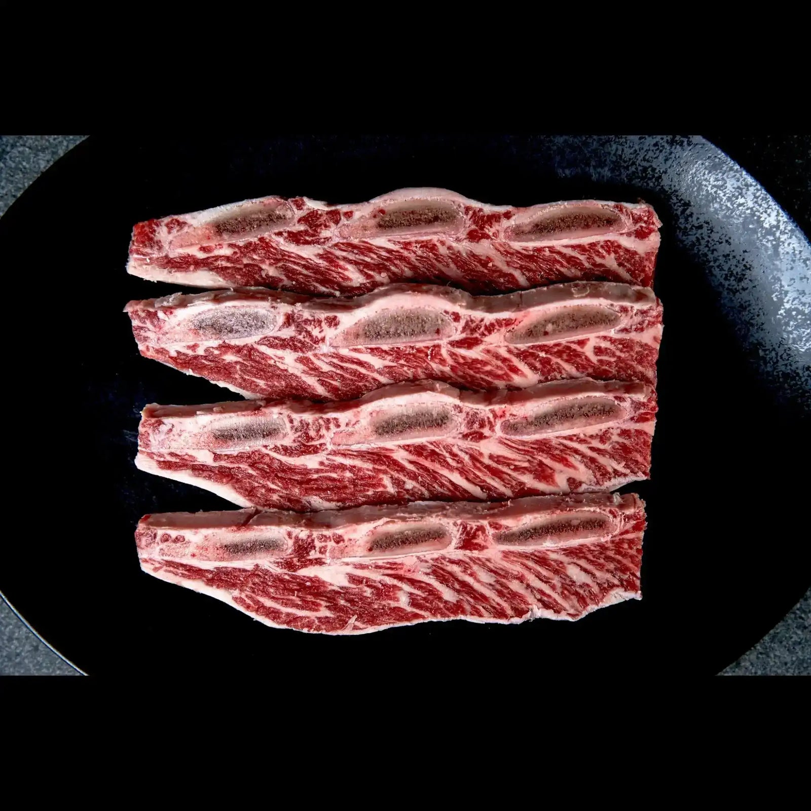 Australian Angus asado ribs with rich marbling on a plate, Peter Augustus premium beef