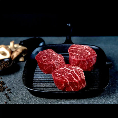 Three raw Australian Wagyu eye fillet steaks with marbling in a grill pan from Peter Augustus