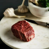 Raw Wagyu beef tenderloin eye fillet steak on marble board with garlic and knife