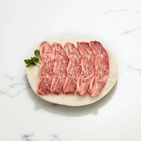 Australian Angus asado ribs with rich marbling on a plate, Peter Augustus premium beef